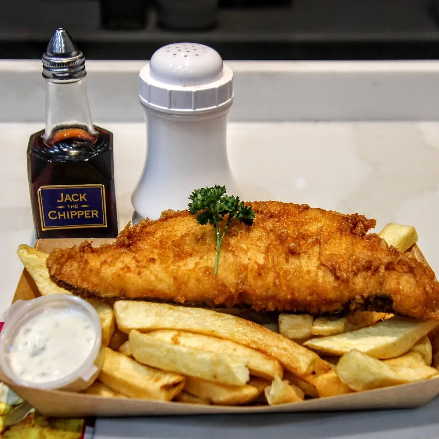 Battered cod and chips with tartar sauce and Jack The Chipper vinegar