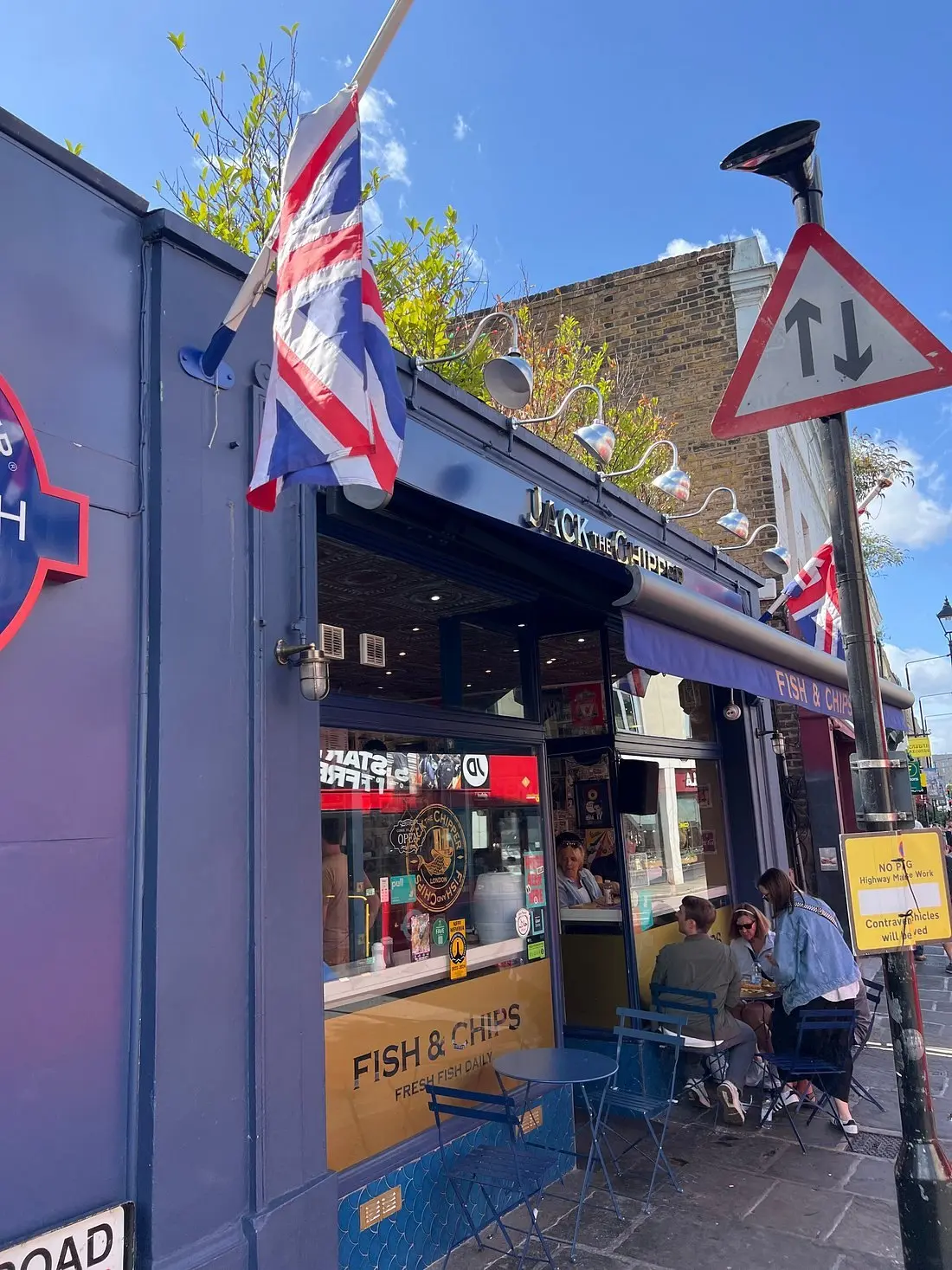 The blue shopfront with Union Jack flags flying above the pavement